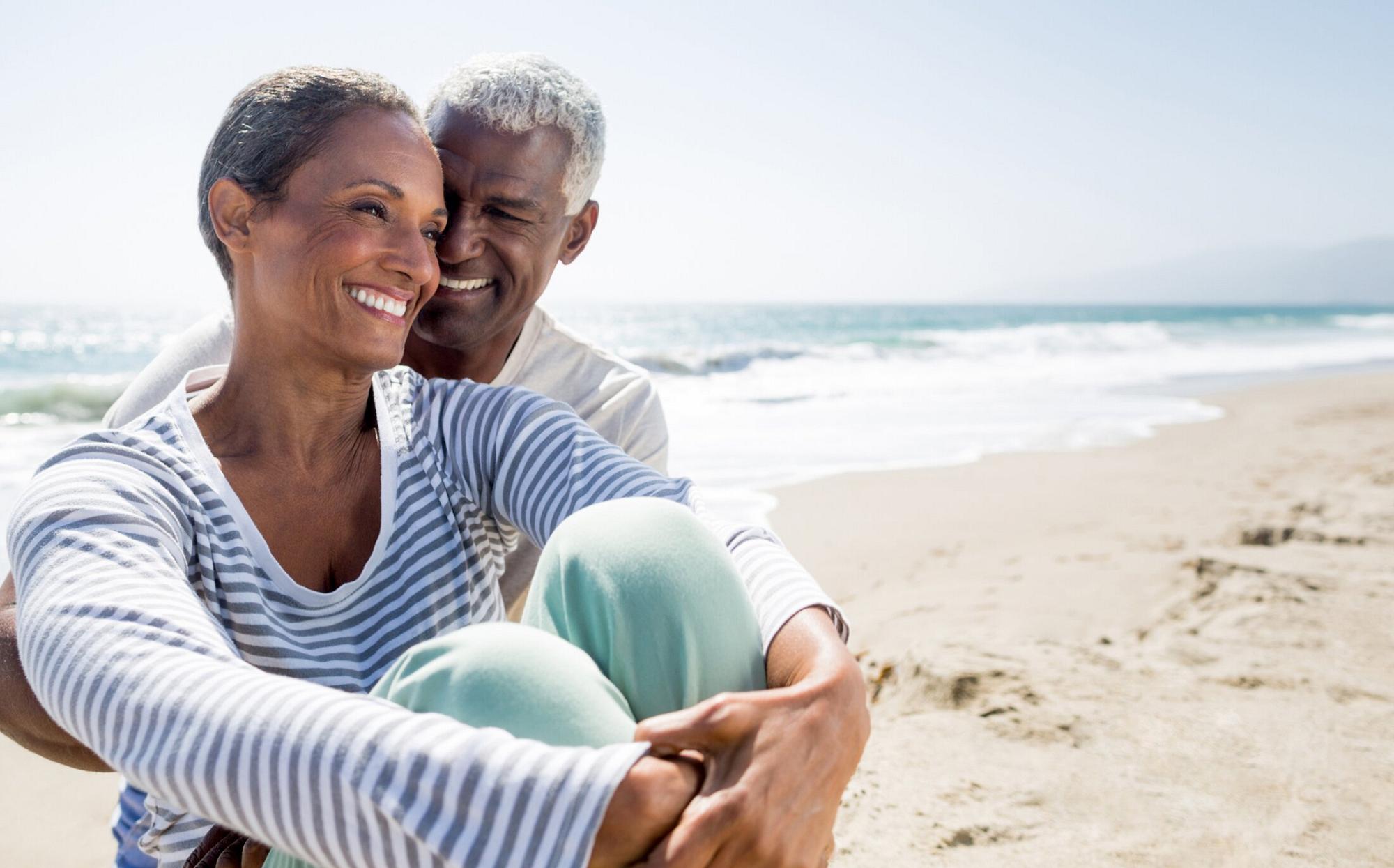 Older couple smiling on the beach