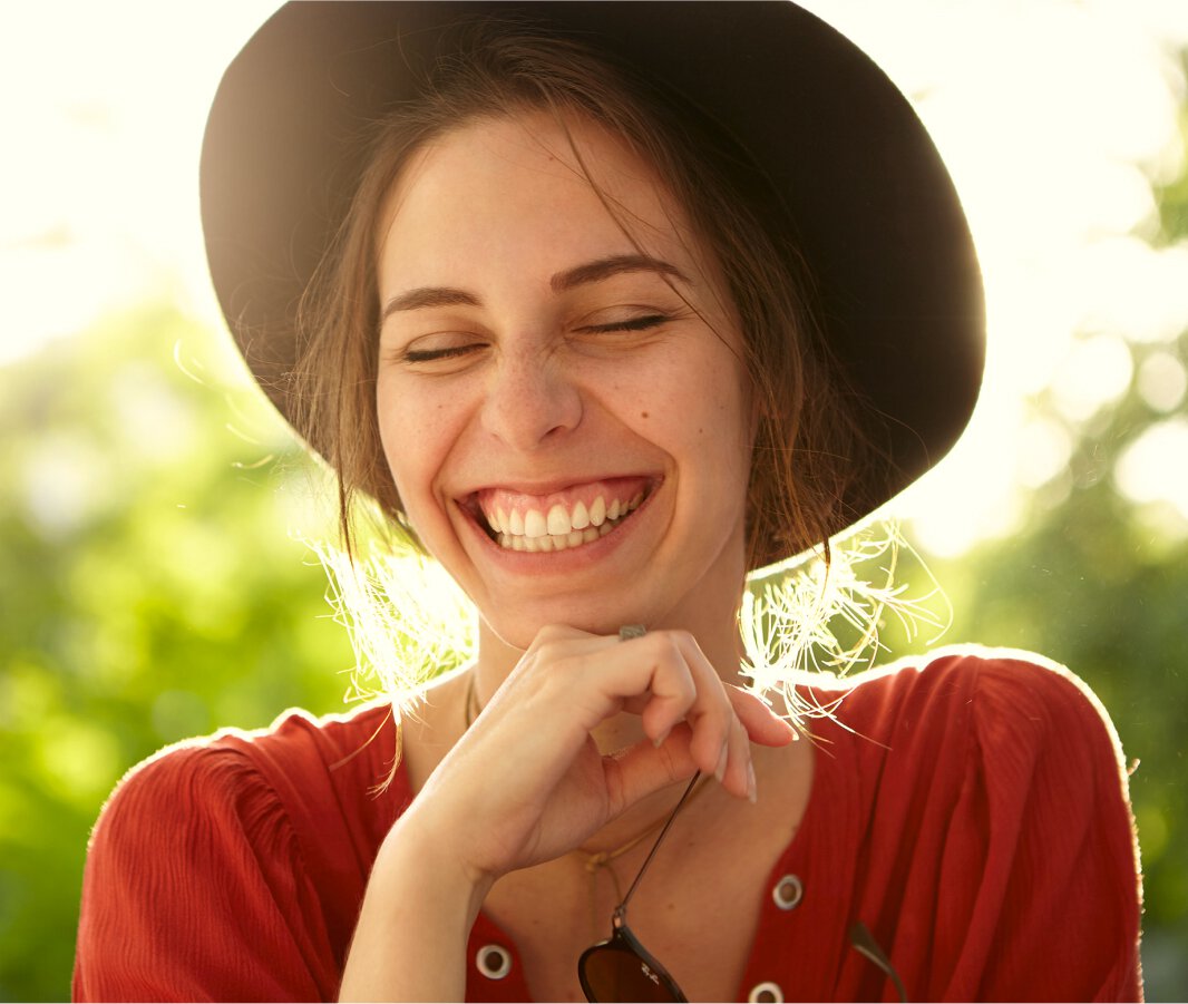 Woman in hat smiling showing nice teeth