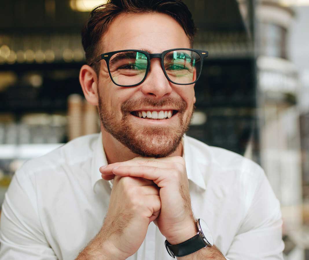 Man with glasses smiling showing good teeth